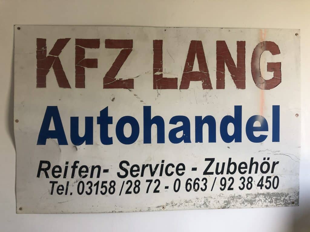 KFZ Lang in rot, darunter Autohandel in blau, darunter in schwarzer Schrift Reifen - Service - Zubehör sowie die Telefonnummer 03158/28 72